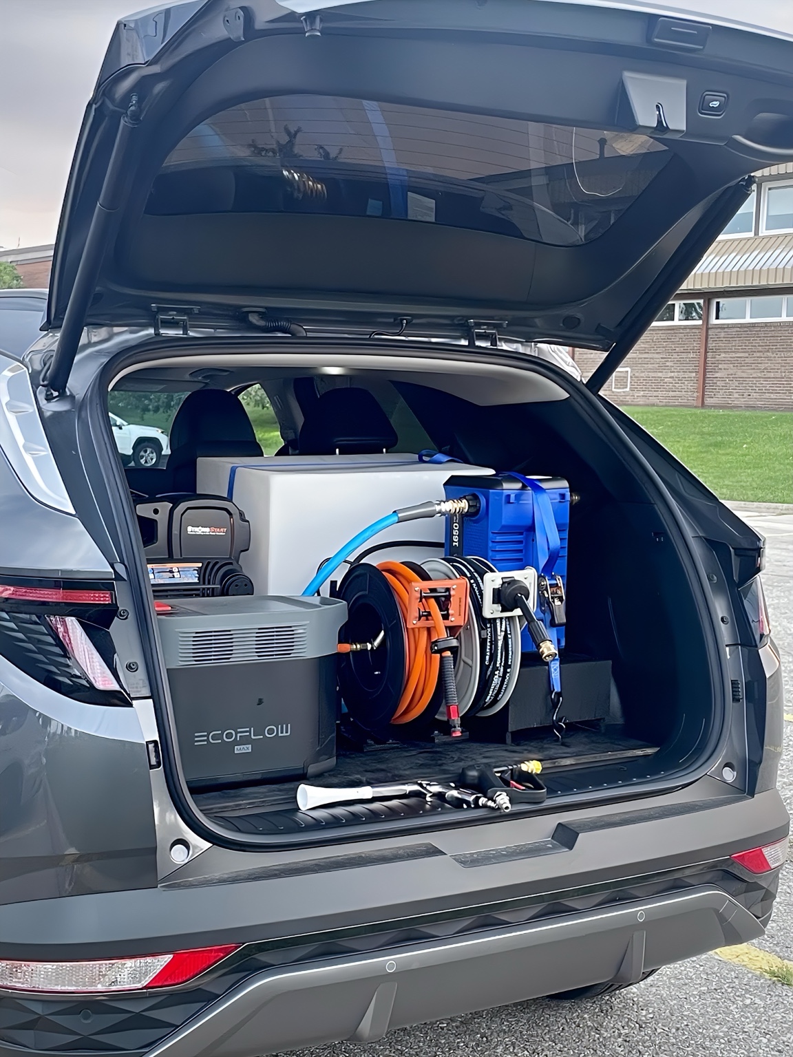 Mobile detailing setup with EcoFlow power unit and hose reels.